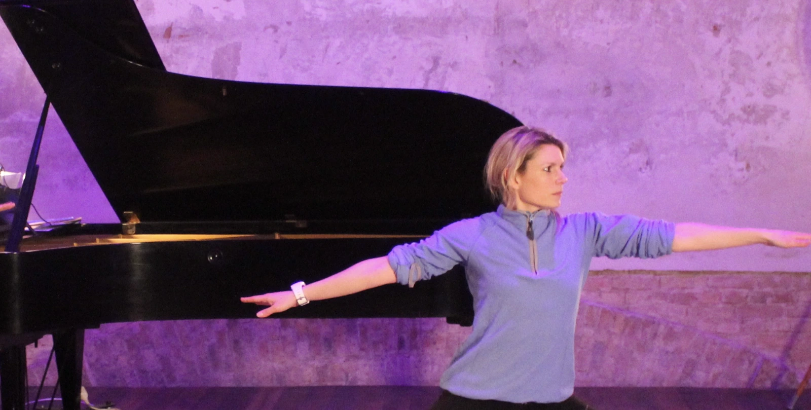 Jo guiding movement beside a grand piano